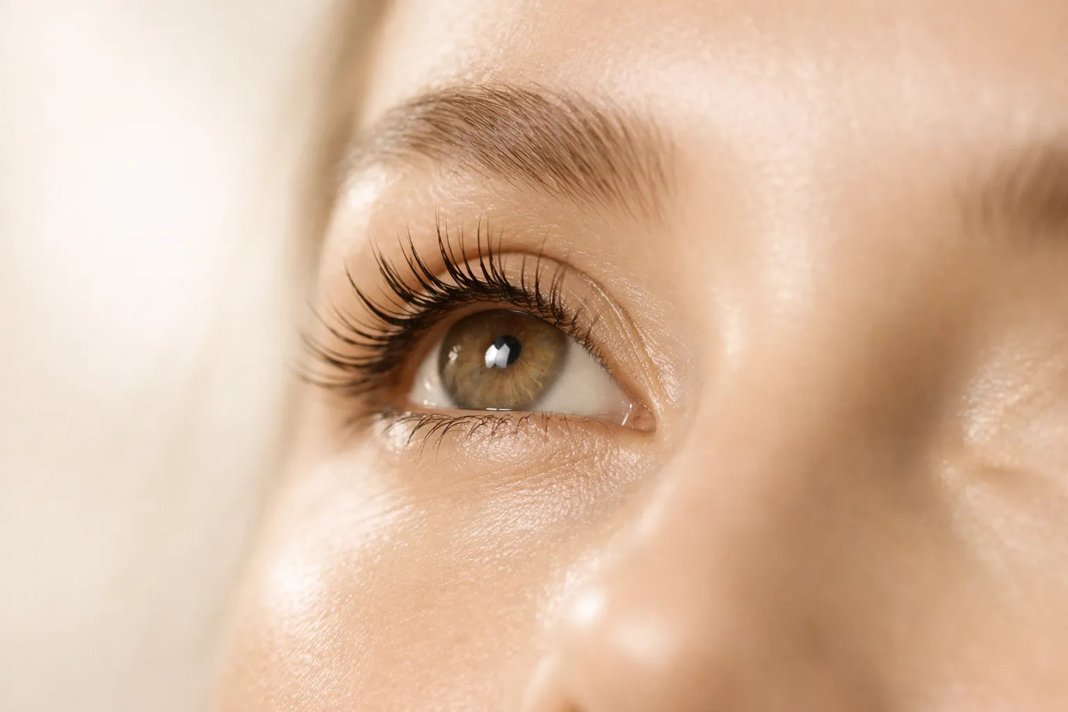 Close-up of a woman’s eye with long, healthy natural eyelashes in a luxury clean beauty editorial style